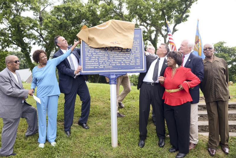 Proudly unveiling the marker (l-r) are, the Rev. Ellis Louden, presiding elder Dover District AMEC; the Rev. Deborah McCaffity, St. George AME; Sen. Ernie Lopez; Stephen Marz, director and Delaware state archivist; Rep. Stephen Smyk; Leonia Robinson; Lewes Mayor Ted Becker; and the Rev. George Edwards, Friendship Baptist Church.